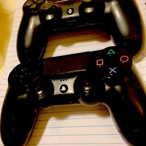 2 black ps4 controllers
